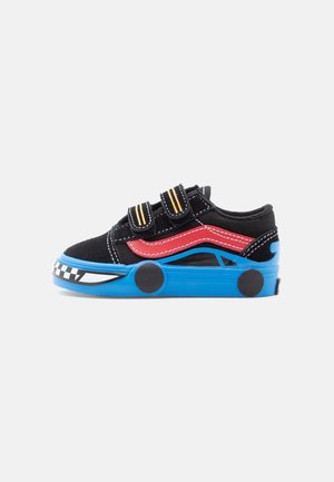 Baskets noires pour enfants avec bande latérale rouge, semelle bleue en forme de voiture, roues noires et deux bandes velcro jaunes rayées.