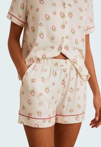 Kortärmad pyjamaset i lätt material, med ett jordgubbsmönster i rött och grönt, elastisk midja och dekorativ piping.