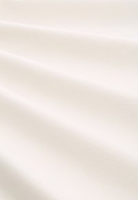 Soft, textured fabric in ivory color, draped with gentle folds, creating a smooth, flowing appearance.