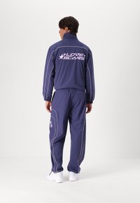 Love Scars COACH TRACKPANTS UNISEX - Παντελόνι - midnight purple