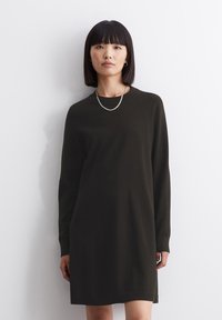Abito in maglia di un verde oliva scuro, caratterizzato da maniche lunghe, scollatura a girocollo e una silhouette dritta con spacco laterale all'orlo.