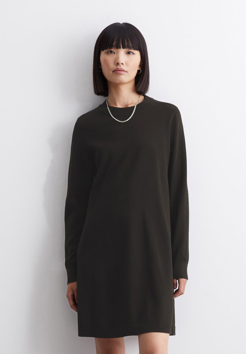 Abito in maglia di un verde oliva scuro, caratterizzato da maniche lunghe, scollatura a girocollo e una silhouette dritta con spacco laterale all'orlo.