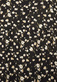 Tessuto nero con un motivo floreale che presenta fiori bianchi e beige, con sottili gambi verdi. La texture appare morbida con sottili pieghe.