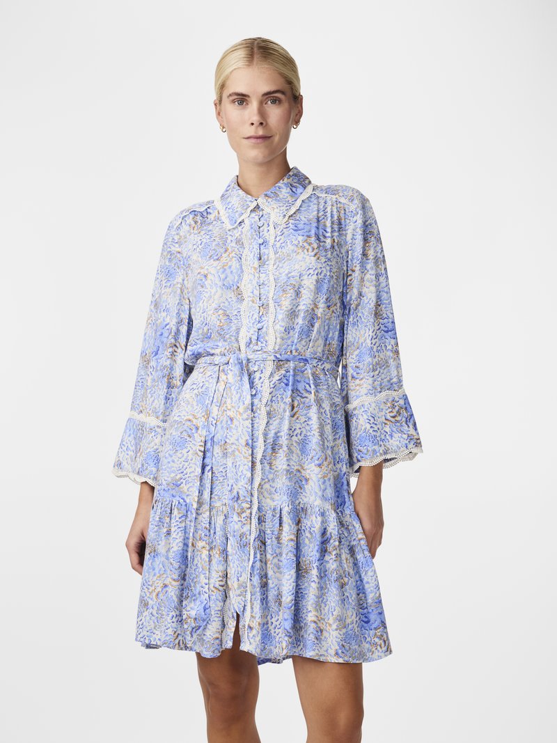 Rochie cu imprimeu floral în nuanțe de albastru deschis și crem. Prezintă un guler, mâneci lungi tip clopot și o margine ruffled în straturi. Material ușor.