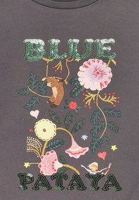 Gray fabric t-shirt featuring floral prints and a bear. Green sequined text reads "BLUE PATAYA," with various colorful accents and shapes.