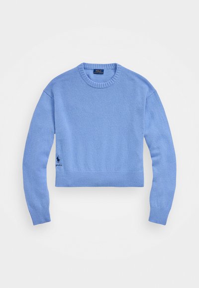 Svetlo modri skrajšan pulover iz mehkega pletenega materiala z rebrastim ovratnikom in robom, s majhnim temnim logotipom na levi strani.