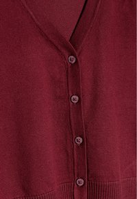 Burgunderfarbener Cardigan mit V-Ausschnitt, ausgestattet mit sechs runden Knöpfen und einem gerippten Saum. Hergestellt aus weichem Strickmaterial, das eine glatte Textur bietet.