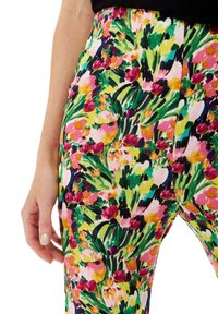 Colorful floral-patterned trousers featuring a mix of pink, green, and yellow hues with a fitted design and smooth texture.