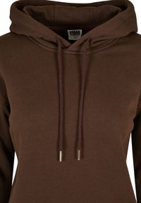 Sweat à capuche en coton marron avec capuche à cordon, tissu épais et embouts métalliques argentés sur les cordons. Design simple, sans motifs ni accents.
