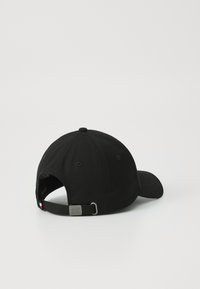 Black baseball cap with a curved brim, made of fabric. Features an adjustable strap with metal hardware at the back.