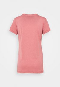 En enhetlig korallrosa t-shirt med kort ärm och rund halsringning, sedd bakifrån mot en enkel vit bakgrund.