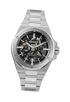 Montre automatique en acier inoxydable avec un cadran squelette noir, des accents argentés et un bracelet à maillons ; elle présente des index et des aiguilles de grande taille.