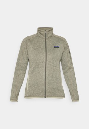 Veste en polaire grise claire à zip intégral avec col montant, poche zippée sur la manche, poches latérales et logo Patagonia sur la poitrine.