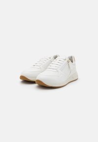 Scarpe da ginnastica bianche con pannelli perforati, suole ammortizzate e una suola in gomma color miele. Tra le caratteristiche ci sono i lacci e una zip laterale.