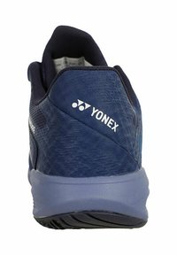 Scarpa sportiva Yonex con tomaia texture di colore blu scuro, suola blu chiaro e logo bianco ben visibile sul tallone. Design semplice senza motivi visibili.