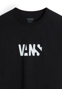 Black cotton t-shirt featuring a white graphic logo "VANS" in varying styles and sizes. Simple crew neck design with a loose fit.