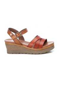 Sandalo con zeppa e suola simile al sughero, caratterizzato da cinturini in pelle marrone testurizzata, fibbia regolabile e design aperto sulla punta.