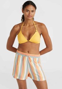 Dzeltena trīsstūrveida bikini augšdaļa, kas saskaņota ar svītrainām šortiem, kuros ir oranža, zila un balta krāsa. Šortiem ir elastīga josta un aukliņa.