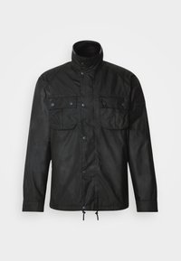 Black outerwear jacket with a high collar, two front pockets, snap closures, and adjustable drawstring at the hem. Smooth, textured fabric.
