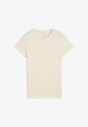 Krátký rukáv světle béžové tričko vyrobené z měkké bavlny, s malou bílou nášivkou loga Puma na horní levé části hrudi.