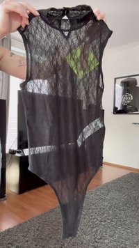 Sort blonde bodysuit med ærmeløs design, transparent tekstur og markante udskæringer. Har en høj krave og snæver bund.