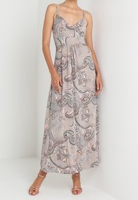 Maxi jurk met spaghettibandjes van lichtbeige stof, voorzien van een paisleypatroon in pastelkleuren en een gathered taille-detail.