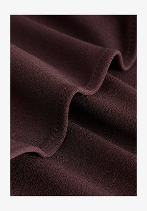 Într-o nuanță profundă de burgund, materialul are o textură moale și netedă, evidențiind valuri subtile și margini cusute. Suprafața pare bogată și ușor texturată.