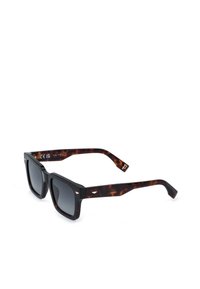 Lunettes de soleil rectangulaires noires avec verres foncés et branches épaisses à motif écaille, positionnées en angle sur un fond blanc.
