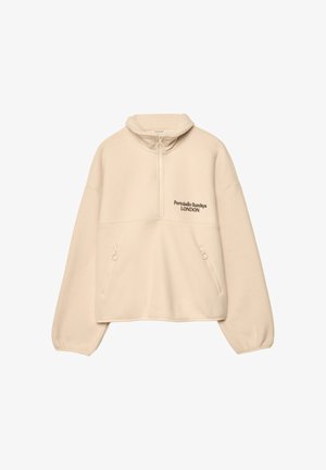 Pulover kremne barve iz mehke tkanine, z zapiranjem na četrtinski zadrgi, stranskimi žepi in izvezenim napisom "Portobello Sundays LONDON."