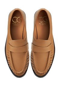 Bruine leren loafers met een gladde afwerking, voorzien van een decoratieve band en een textuurdetail aan de zijkanten. Zwarte rubberen zolen zorgen voor contrast.