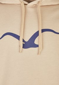 Felpa beige con un grande design astratto blu navy sulla parte anteriore, dotata di cappuccio con coulisse e tessuto testurizzato.