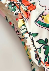 Kleurrijke bikini-top met een bloemenpatroon, ruches aan de rand en versterkte stiksels. Het materiaal lijkt soepel met een elastische textuur.