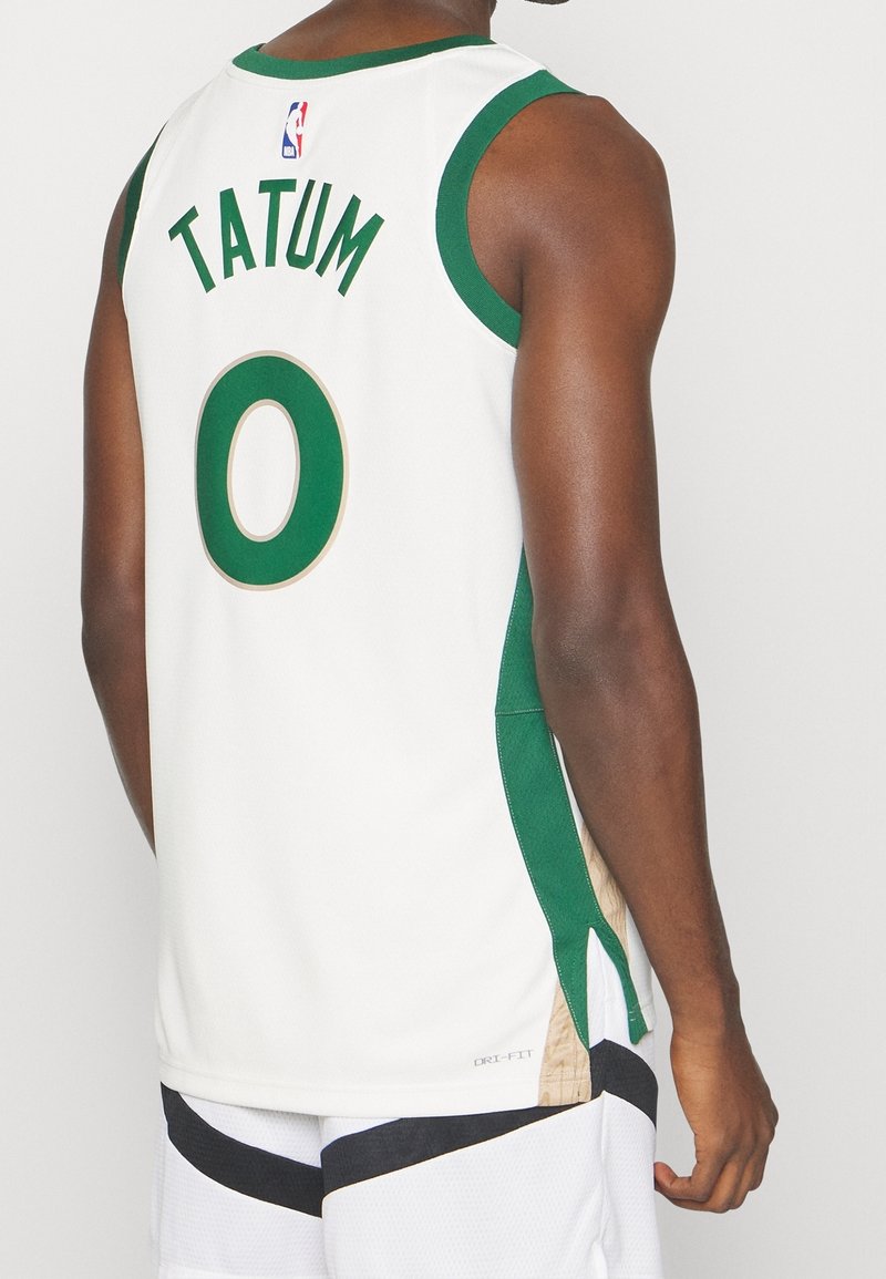 Maglia da basket bianca con rifiniture verdi, con la scritta "TATUM" e il numero "0" in verde e oro, e dettaglio DRI-FIT all'orlo.
