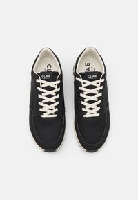 Svarte mesh-sneakers med semsket detaljer, kremfargede lisser og en kremfarget såle. Har en avrundet tå og merkevare på tungen.