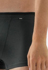 Svarta boxershorts med ett rutigt mönster, slät textur, elastiskt midjeband och en liten logotyp fram.