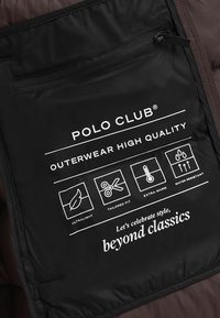 Svart tyg med vit tryckt text som beskriver egenskaper: ultralätt, skräddarsydd passform, extra varm, vattenresistent, med ikoner för varje.