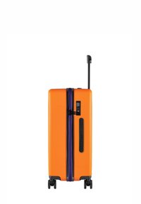 Pomarańczowa walizka z twardą skorupą, fioletowym zamkiem błyskawicznym, wysuwanym czarnym uchwytem i czterema kółkami. Zawiera zamek szyfrowy.