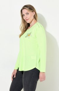 Neon-grünes Langarmshirt mit Sternenmotiv, ausgestattet mit silbernen und orangen Akzenten, rundem Ausschnitt und geschwungenem Saum.