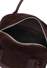 Tamsiai rudos spalvos zomšinė rankinė su viršutiniu užtrauktuku, matoma užtrauktuko kišenė ir siuvinėta odinė rankena.