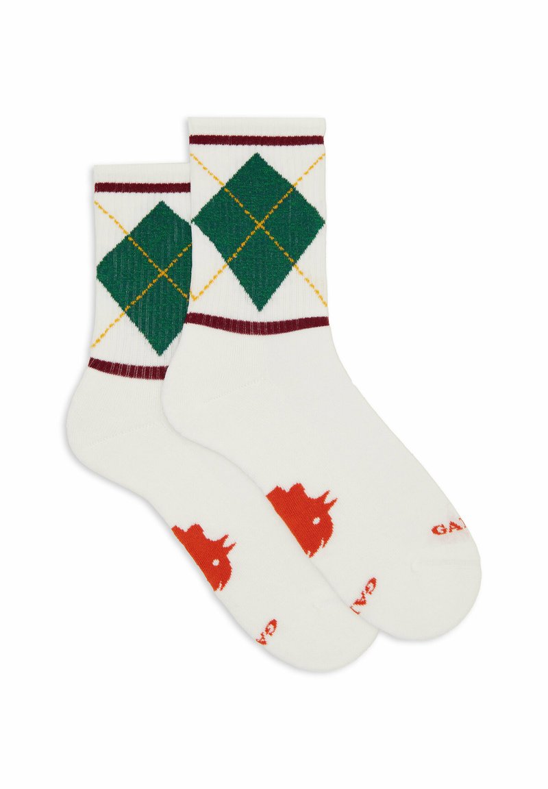 Calze bianche alla caviglia con motivo argyle verde e giallo sui polsini e logo a corona rossa vicino alle dita.