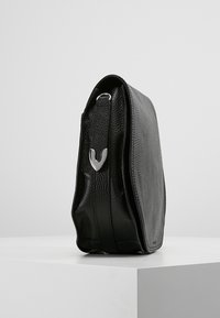 Borsa in pelle nera con finitura testurizzata, vista laterale che mostra una forma elegante, dettagli in metallo argento e un design minimalista.