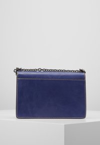 Borsa a tracolla in pelle blu con tracolla a catena, forma rettangolare, cuciture visibili e texture liscia. Design minimalista senza ulteriori decorazioni.