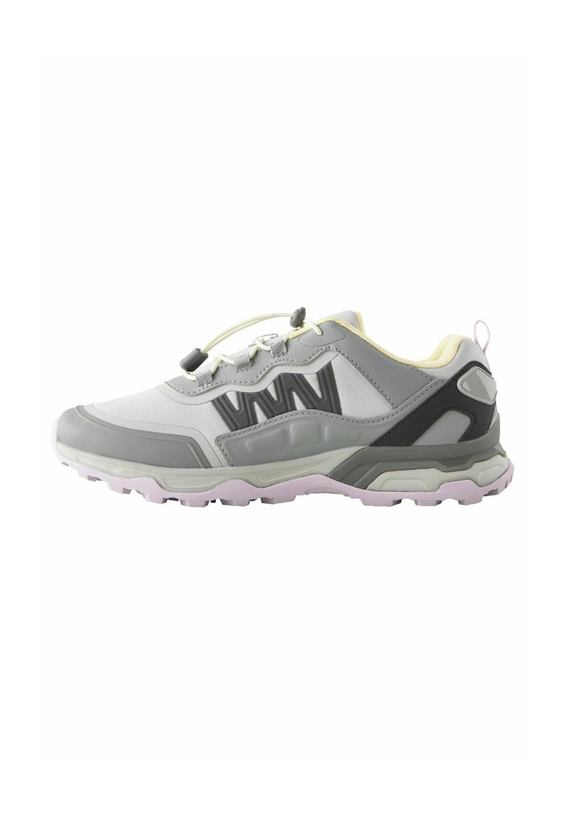 Chaussure de sport grise et blanche avec une tige texturée, semelle en caoutchouc et lacets élastiques. Présente des accents jaunes et un talon renforcé.
