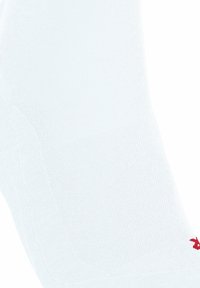 Chaussette de sport blanche avec une texture côtelée, arborant un détail de logo rouge. Conçue avec un ajustement anatomique pour un confort amélioré.