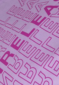 Lila tyg med ett geometriskt mönster skapat av varierande former och bokstäver i en mörkare lila nyans, med en jämn yta och mjuk textur.