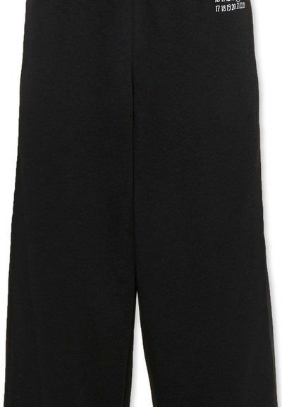 Pantalon noir avec un imprimé de calendrier blanc sur la partie supérieure de la cuisse, montrant les dates sous forme de grille.