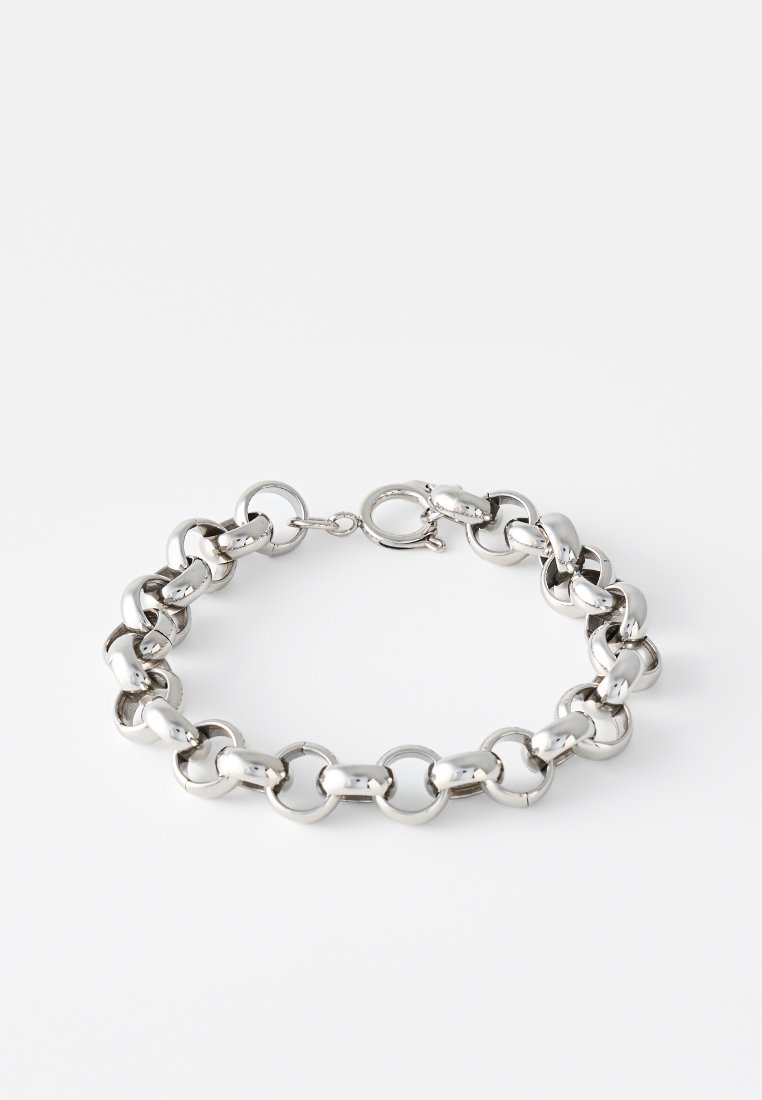 Bracciale in metallo argento composto da anelli ovali e rotondi interconnessi, con chiusura a moschettone. Superficie liscia e lucente con un design senza soluzione di continuità.