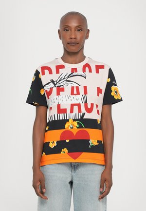 Kortærmet t-shirt i bomuldsblanding med multicolor prints. Har stort rødt tekst "PEACE," blomsterdesigns og stribede mønstre i varierende farver.