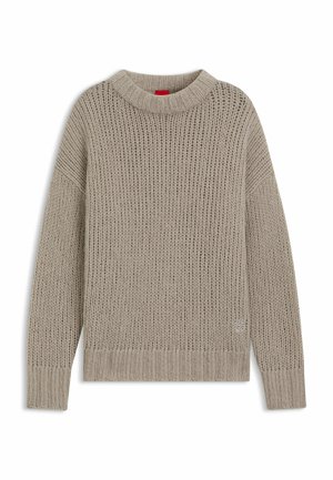 Beige gestrickter Pullover mit hohem, geripptem Kragen, überschnittenen Schultern und gerippten Bündchen. Mit strukturiertem Muster und Logodetail am Saum.