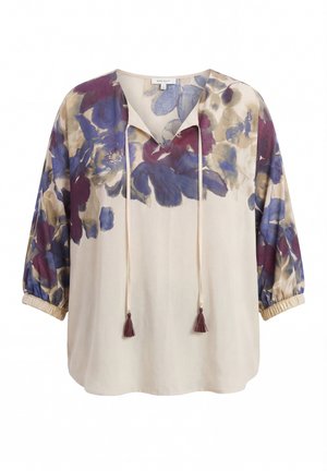 Beige blouse met paarse en blauwe bloemenprint op de schouders en mouwen, V-hals met stropdraad die eindigt in kwastjes, elastische mouwboorden.